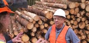 Marcel Leboeuf devant pile de bois