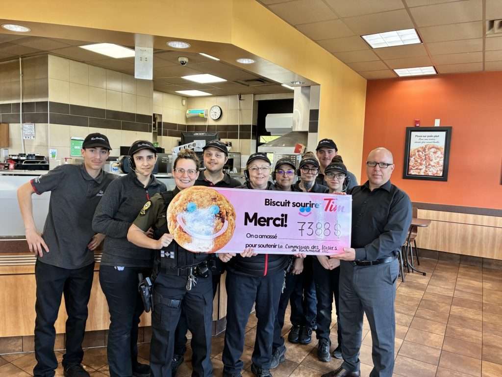 de gauche à droite : Sergente Stéphanie Lemay coordonnatrice locale en police de proximité de la Sureté du Québec CSMRC-Richmond, Mme Renée Goudreault gérante du Tim Hortons de Richmond, M. Jean-Martin Lavoie directeur du service récréatif à la Ville de Richmond ainsi que plusieurs membres de l’équipe du Tim en arrière-plan.