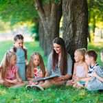 Enfants écoute un conte dans un parc.