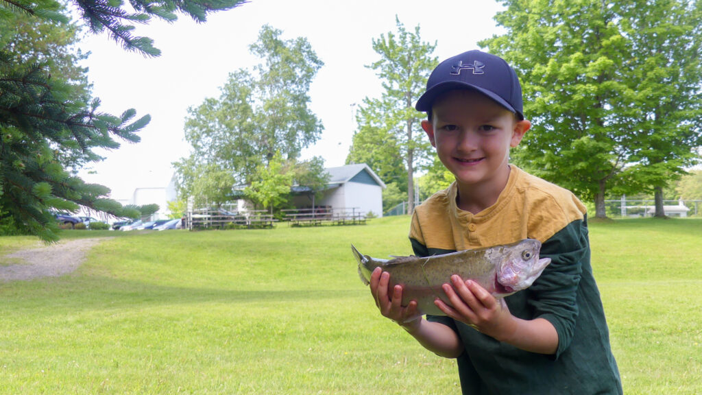 Jeune garçon tenant un poisson.