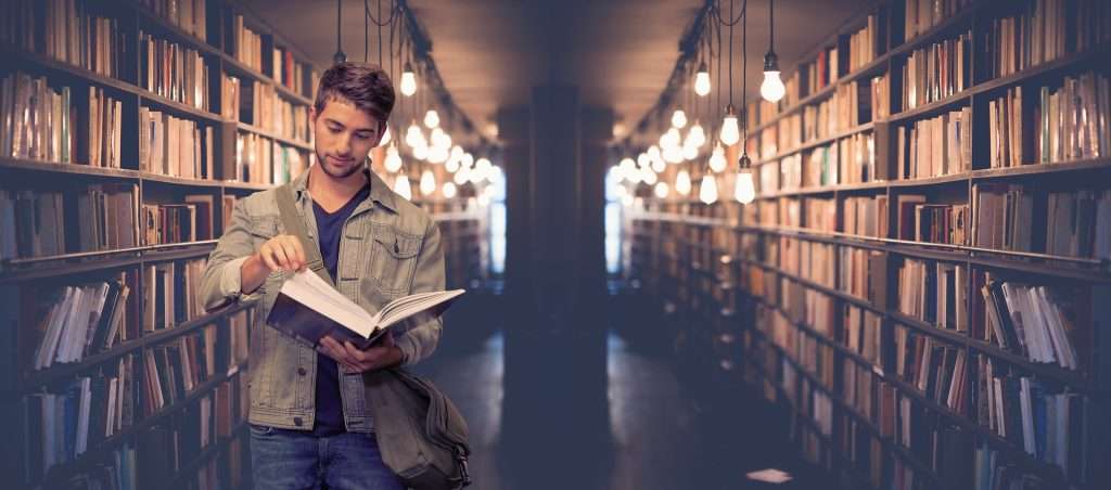 étudiant qui feuillète un livre à la bibliothèque.