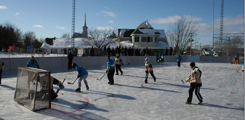Des enfants jouent au hockey sur la patinoire des Loisirs de Racine